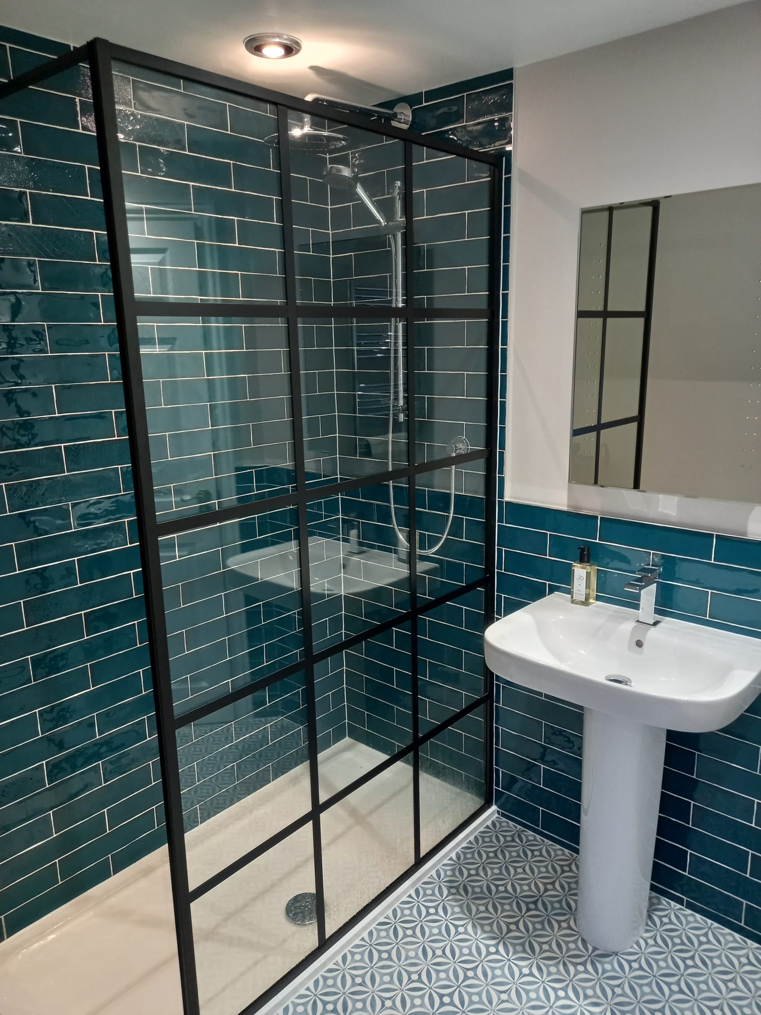 Bathroom installation with sink, mirror and walk in shower