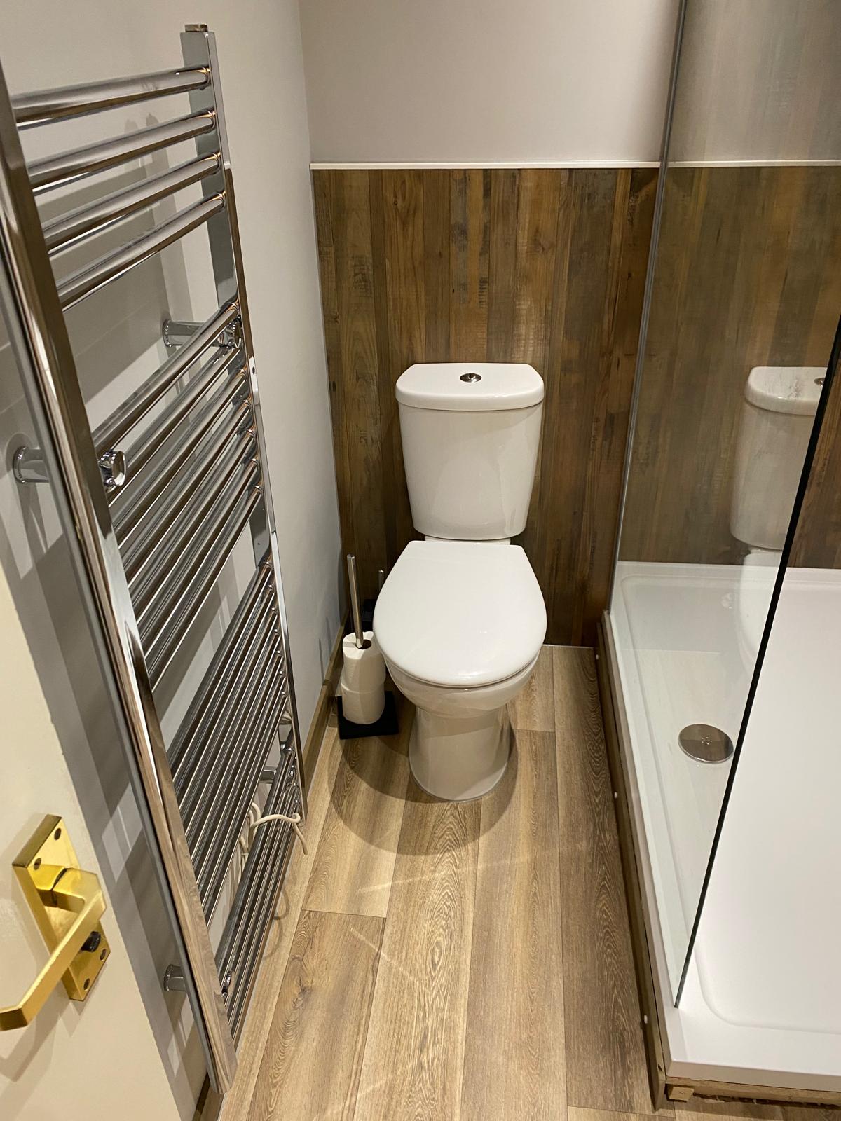 Bathroom installation with toilet and heating rack